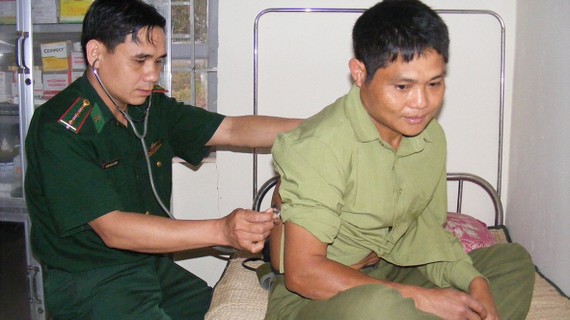 Thượng úy Trần Văn Cường khám bệnh cho người dân  bản Huồi Bắc (xã Bắc Lý, huyện Kỳ Sơn)