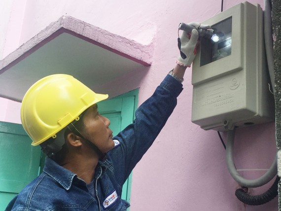 Nhân viên ngành điện kiểm tra việc lắp đặt  công tơ đo đếm từ xa mới tại nhà dân