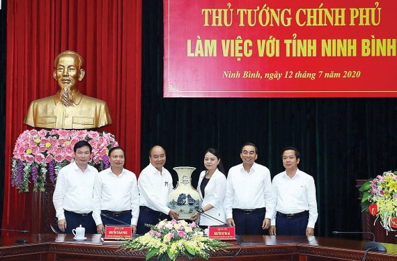 Thủ tướng Nguyễn Xuân Phúc tặng quà lưu niệm cho tỉnh Ninh Bình. Ảnh: TTXVN