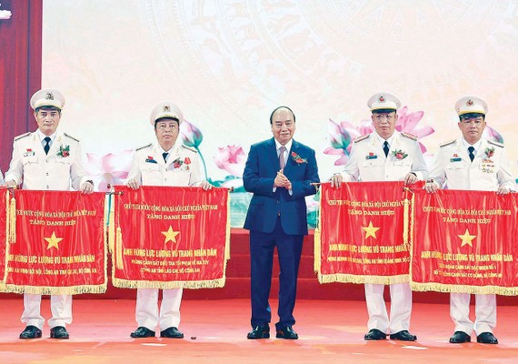 Thủ tướng Nguyễn  Xuân Phúc, Chủ tịch Hội đồng Thi đua - Khen thưởng Trung ương, trao tặng danh hiệu Anh hùng Lực lượng vũ trang nhân dân thời kỳ đổi mới  cho các  tập thể thuộc  Bộ Công an. Ảnh:  QUANG PHÚC