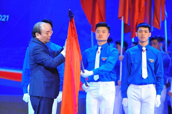 Thủ tướng Nguyễn Xuân Phúc gắn Huân chương Hồ Chí Minh  lên cờ truyền thống của Trung ương Đoàn TNCS Hồ Chí Minh. Ảnh: TTXVN