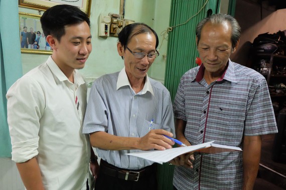 Ông Huỳnh Hải (giữa) tuyên truyền bầu cử cho người dân khu phố 5, phường Linh Đông, TP Thủ Đức