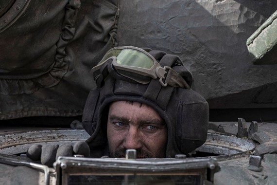 Một quân nhân Ukraine ngồi bên trong chiếc xe tăng Nga bỏ lại sau cuộc giao tranh tại làng Lukyanivka, ngoại ô Kyiv, ngày 27-3. Ảnh REUTERS 