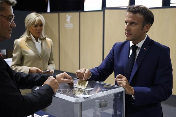 Tổng thống Pháp Emmanuel Macron (phải) cùng phu nhân Brigitte Macron bỏ phiếu bầu cử Quốc hội Khóa XVI tại Le Touquet, ngày 12-6-2022. Nguồn: TTXVN