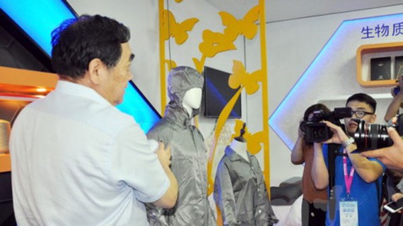 Chủ tịch HĐQT Đường Nhất Lâm tiến hành thí nghiệm về tính dẫn điện của bộ quần áo. Ảnh: TTXVN