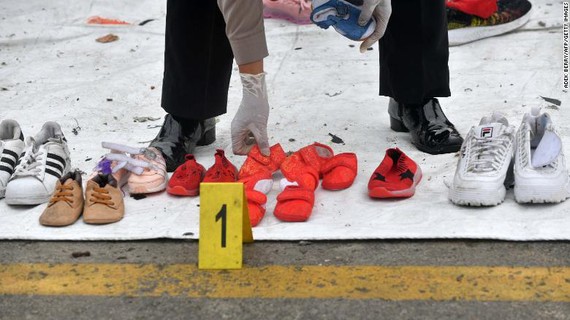 Lực lượng cứu hộ sắp xếp lại các đôi giầy của nạn nhân được tìm thấy. Ảnh: Getty
