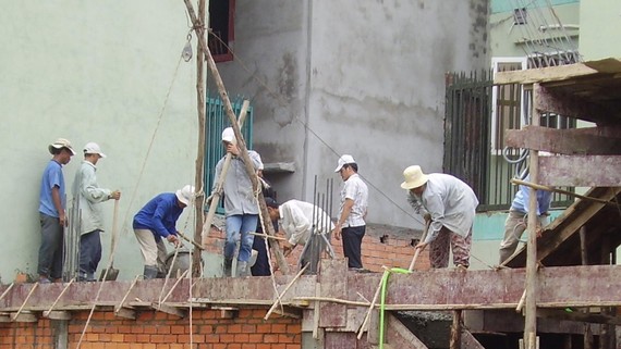 Công trình xây dựng trên cao, nhưng dàn giáo sơ sài, công nhân không được trang bị bảo hộ lao động. Ảnh: MINH THANH 