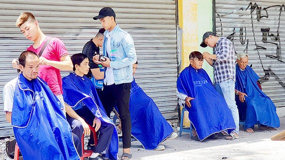 Hớt tóc từ thiện trên đường Nguyễn Khắc Nhu, phường Cô Giang, quận 1, TPHCM. Ảnh: NHƯ KHUÊ