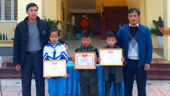 Lãnh đạo trường Tiều học Thạch Bình tặng giấy khen cho các em Đặng Khánh Ly, Nguyễn Quang Huy và Đặng Quốc Thiên