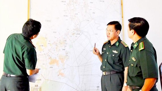 Đại tá Phan Minh Huyền (giữa), Bộ đội Biên phòng tỉnh An Giang, trao đổi về công tác phòng chống tội phạm trên bản đồ biên giới