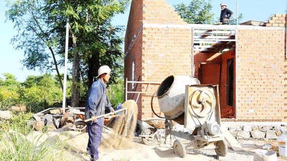 Anh Trần Ngọc Tài (huyện Cư Mgar, tỉnh Đắk Lắk) bên căn nhà đang  được xây mới từ “Quỹ tiết kiệm 1.000 đồng”