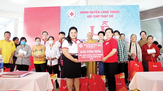 Bà Nguyễn Thu Thủy - đại diện Vedan trao bảng tượng trưng 4 căn nhà  cho đại diện Hội Chữ thập đỏ huyện Long Thành, tỉnh Đồng Nai