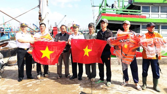 Vùng 4 Hải quân tặng cờ tổ quốc cho ngư dân Bình Định. Ảnh: NGỌC OAI