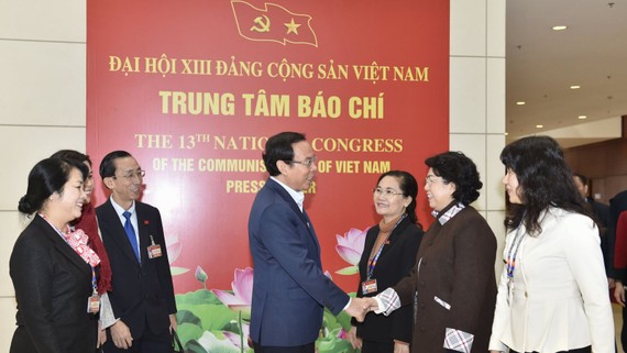 Bí thư Thành ủy TPHCM Nguyễn Văn Nên trao đổi cùng các  đại biểu đoàn TPHCM tại Đại hội XIII của Đảng trong ngày 29-1. Ảnh VIẾT CHUNG