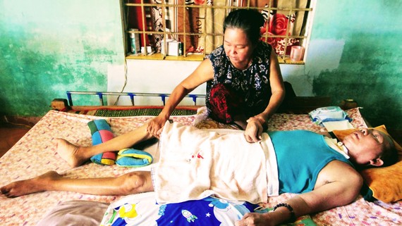 Bà Trần Thị Tiếp chăm sóc người chồng bị đột quỵ,  nằm liệt giường gần 10 năm qua