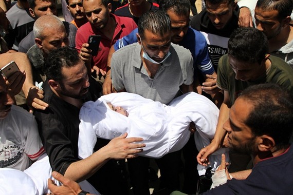 Một người Palestine ôm thi thể của một đứa trẻ bị giết trong cuộc không kích của Israel vào nhà của họ, trong lễ tang ở thành phố Gaza, ngày 16 tháng 5 năm 2021. [Ảnh / Tân Hoa xã]