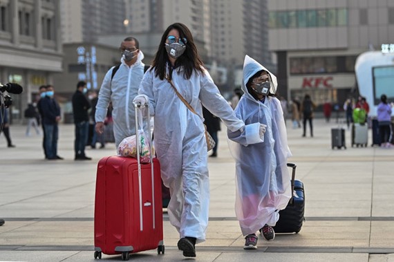 Người dân trong trang phục bảo hộ rời thành phố Vũ Hán (Trung Quốc) vào ngày 8.4 AFP
