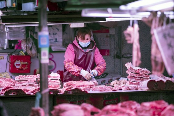 Một người bán hàng chuẩn bị thịt lợn tại một khu chợ ở Thượng Hải.  Nhiếp ảnh gia: Qilai Shen / Bloomberg