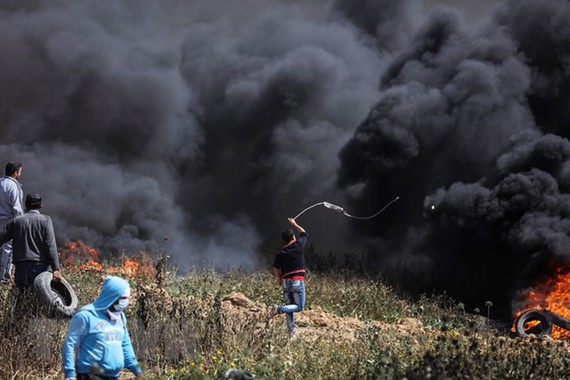 Người biểu tình Palestine đốt lốp xe và ném đá vào binh sỹ Israel. Nguồn: TTXVN
