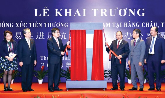 Thủ tướng Nguyễn Xuân Phúc và các đại biểu thực hiện nghi thức kéo vải mở biển hiệu, khai trương Văn phòng Xúc tiến thương mại Việt Nam tại Hàng Châu