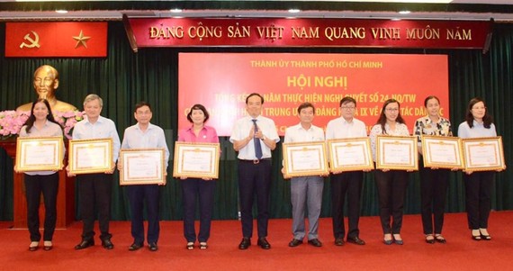 Đồng chí Trần Lưu Quang, Phó Bí thư Thường trực Thành ủy TPHCM  trao Bằng khen cho các tập thể. Ảnh: hcmcpv