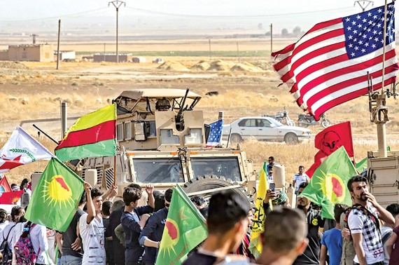 Người Kurd tại Syria vây quanh xe quân sự của Mỹ ở ngoại ô thị trấn Ras al-Ain, tỉnh Hasakeh (Syria), gần biên giới Thổ Nhĩ Kỳ