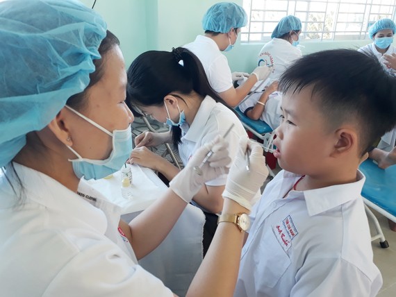 Các bác sĩ Bệnh viện Răng Hàm Mặt TPHCM đang trám răng cho các em học sinh