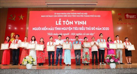 Ban Chỉ đạo vận động hiến máu tình nguyện thành phố Hà Nội tặng Giấy khen cho các gia đình có thành tích xuất sắc tham gia phong trào hiến máu tình nguyện. Ảnh: Thanh Tùng/TTXVN