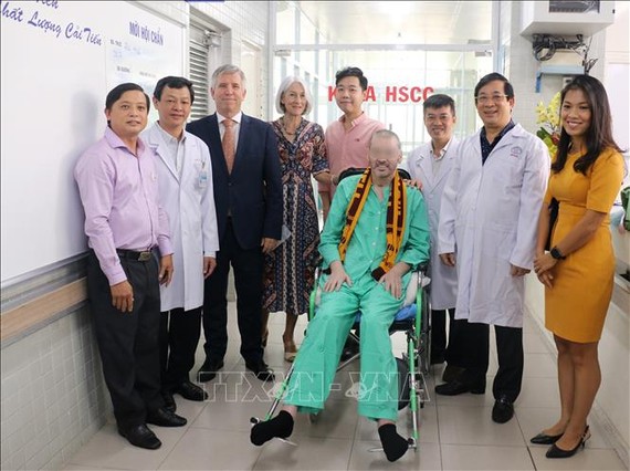 Bệnh nhân 91 chụp ảnh lưu niệm với đại diện Lãnh sự quán Anh tại Thành phố Hồ Chí Minh và các y bác sỹ trong ngày xuất viện sáng 11-7. Ảnh: TTXVN