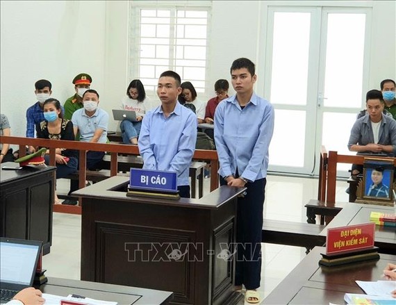 Bị cáo Đinh Văn Giáp (trái) và bị cáo Đinh Văn Trường tại phiên xét xử. Ảnh: TTXVN