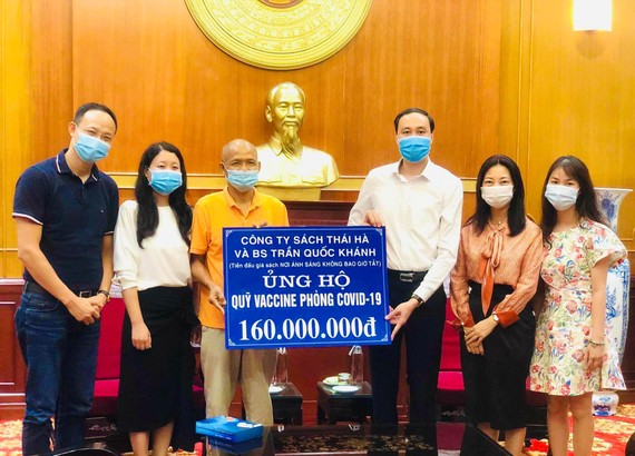 Bác sĩ Trần Quốc Khánh cùng đại diện của Thái Hà Books trao tặng số tiền 160 triệu đồng từ chương trình đấu giá sách ủng hộ Quỹ vaccine phòng Covid-19