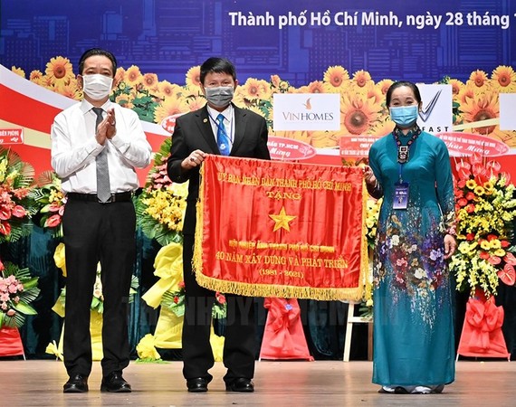 Phó Giám đốc Sở Văn hóa và Thể thao TPHCM Võ Trọng Nam trao tặng Cờ Truyền thống của UBND TPHCM cho Hội Nhiếp ảnh TP. Ảnh: hcmcpv
