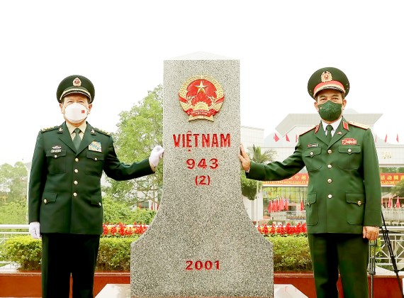 Bộ trưởng Bộ Quốc phòng Phan Văn Giang và Bộ trưởng Bộ Quốc phòng Trung Quốc Ngụy Phượng Hòa chào cột mốc biên giới Việt Nam tại cửa khẩu Tà Lùng. Ảnh: TTXVN