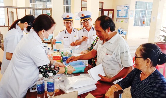 Các y, bác sĩ Vùng 2 Hải quân phối hợp với Bệnh viện Lê Văn Thịnh thăm khám, tư vấn sức khỏe và cấp thuốc miễn phí cho ngư dân xã Bình Châu