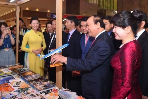 Prime Minister Nguyen Xuan Phuc visits Vietnam Airlines' booth at the event (Photo: VNA)