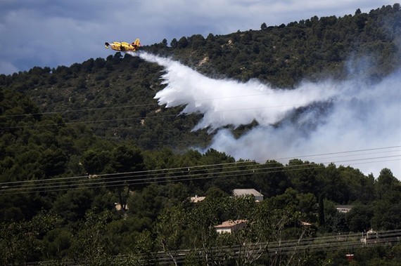 A fire fighting Canadair aircraft drops water over a fire in Mirabeau, southeastern France, on Monday -AFP/VNA