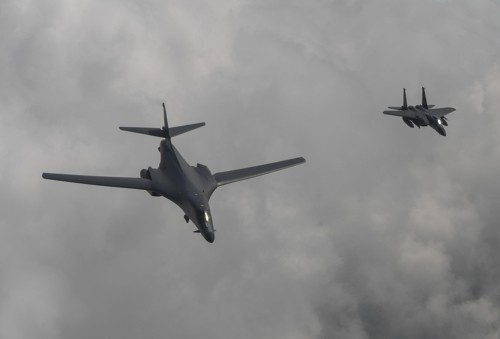 A U.S. B-1B bomber (L) flies over Korea along with a South Korean F-15K fighter on July 30, 2017 in this photo provided by the Air Force. (Yonhap)
