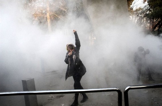 A woman raises her fist amid tear gas at the University of Tehran during a protest on December 30, 2017. – AFP/VNA Photo
