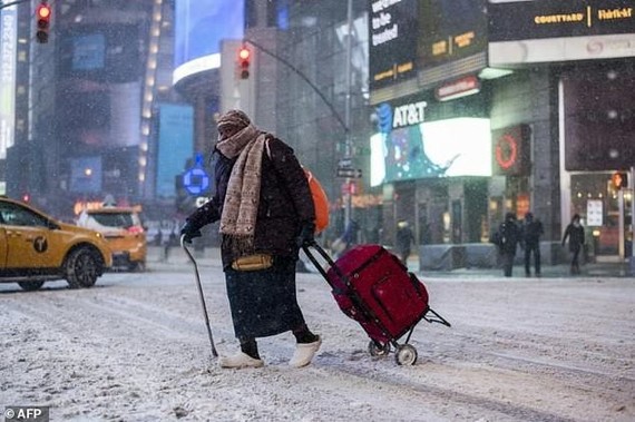 An elderly woman makes her way through New York’s Times Square as snow pelts the Big Apple. — AFP Photo