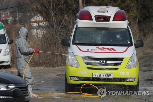 A quarantine official disinfects an ambulance in the vicinity of a layer chicken farm in the city of Pocheon, northeast of Seoul, on Jan. 4, 2018, where the quarantine authorities confirmed an outbreak of an avian influenza virus. (Yonhap)