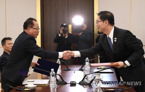 South Korean and North Korean chief delegates shake hands after agreeing at talks on Jan. 17, 2018, to march together under a unified flag at the opening ceremony of the PyeongChang Olympics. (Yonhap)