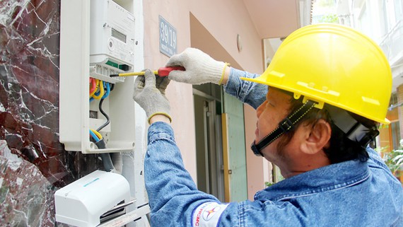 Công nhân điện lực đang thay điện kế điện tử cho khách hàng