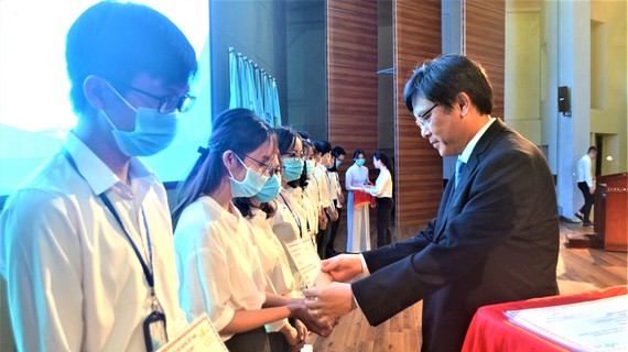 PGS-TS Nguyễn Minh Tâm, Phó Giám đốc ĐH Quốc gia TPHCM, trao học bổng cho sinh viên có hoàn cảnh khó khăn, học giỏi
