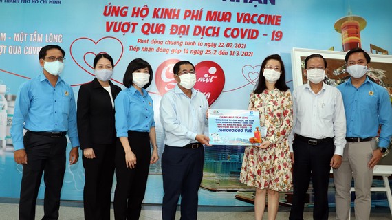 Ông Dương Hồng Nhân, Chủ tịch Hội đồng thành viên Sawaco, thay mặt người lao động tổng công ty trao tiền ủng hộ mua vaccine Covid-19