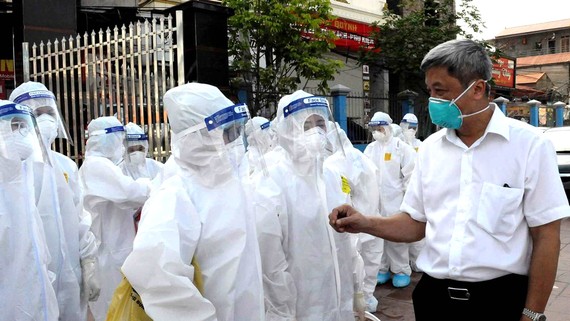 Thứ trưởng Bộ Y tế Nguyễn Trường Sơn động viên cán bộ, nhân viên y tế làm nhiệm vụ lấy mẫu test nhanh ở huyện Việt Yên, Bắc Giang