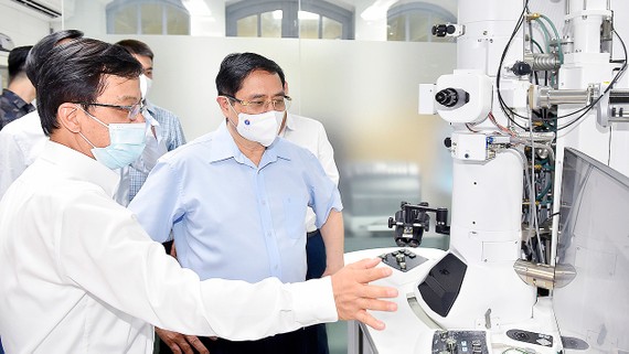 Thủ tướng Phạm Minh Chính tham quan trang thiết bị phục vụ việc nghiên cứu tại Viện Vệ sinh dịch tễ Trung ương. Ảnh: VIẾT CHUNG