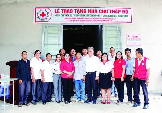 Ông Hwang Fa Jane - đại diện Công ty CPHH Vedan Việt Nam cùng đại diện chính quyền địa phương trong buổi trao tặng nhà cho anh Vi Văn Bé
