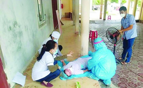 Các đồng nghiệp sơ cứu chị Nguyễn Thị Hương bị ngất xỉu. Ảnh: DƯƠNG QUANG