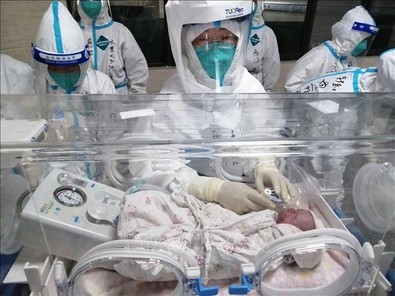 Nhân viên y tế chăm sóc em bé sơ sinh tại bệnh viện ở Thụy Lệ, tỉnh Vân Nam, Trung Quốc, ngày 11-8-2021. Ảnh minh họa: THX
