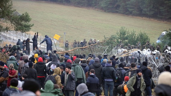 Người di cư gần hàng rào dây thép gai ở biên giới Ba Lan - Belarus. Ảnh: REUTERS
